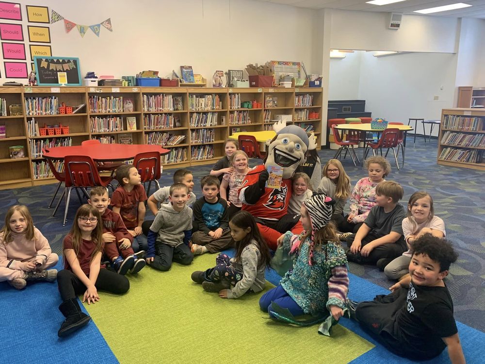 Adirondack Thunder mascot Gunnar sits with children in the Harrison Avenue library