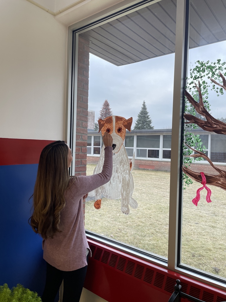 girl draws a painting of a dog on a window