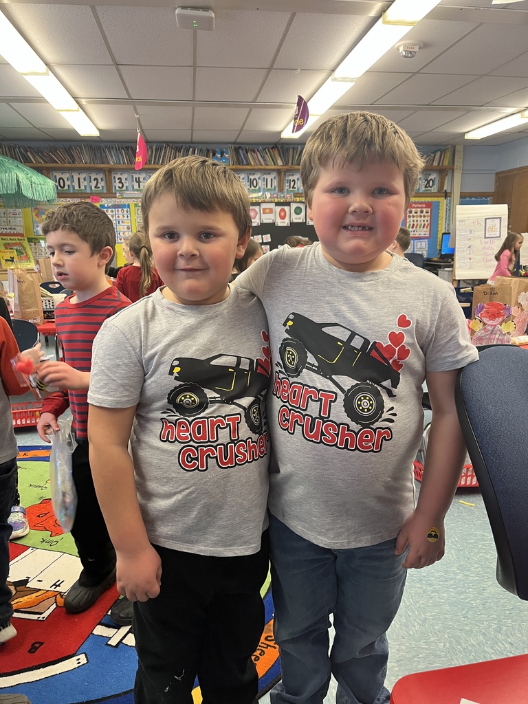 Two boys wear matching shirts with a truck print and "Heart Crusher" written on them.