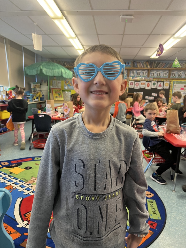 A boy wears blue shutter shades that are heart shaped.